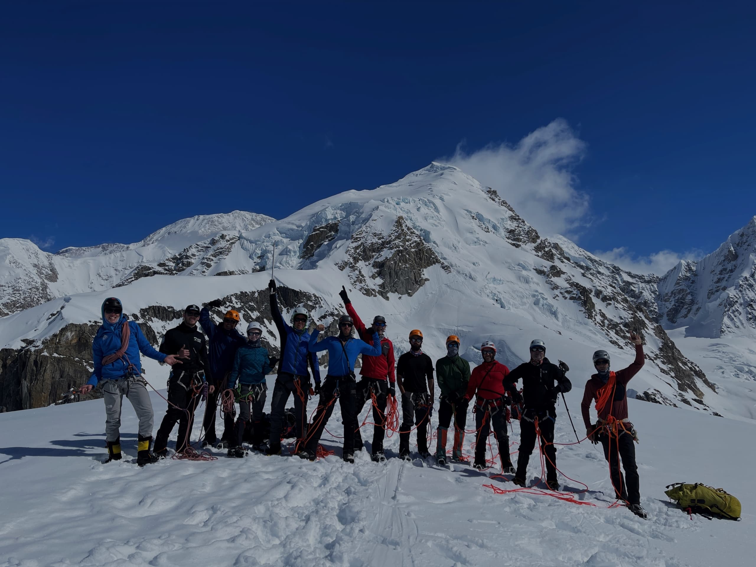 A climbing team moving across a snowy mountainside.