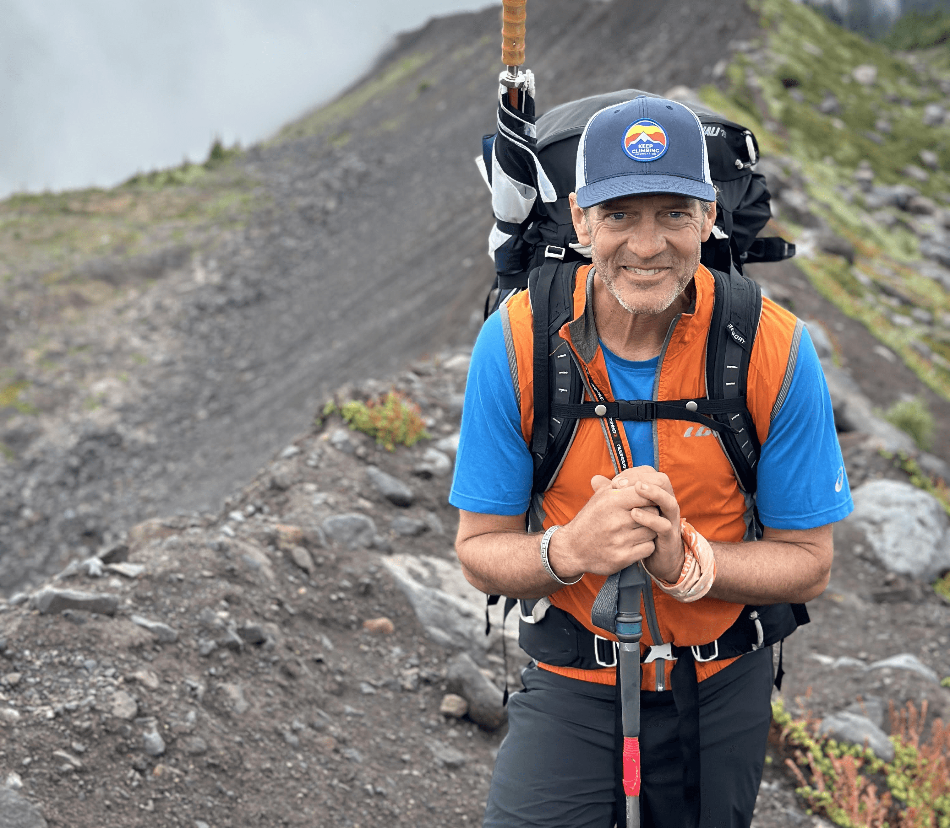 Un simpatizante de Keep Climbing Foundation caminando por un sendero de montana.