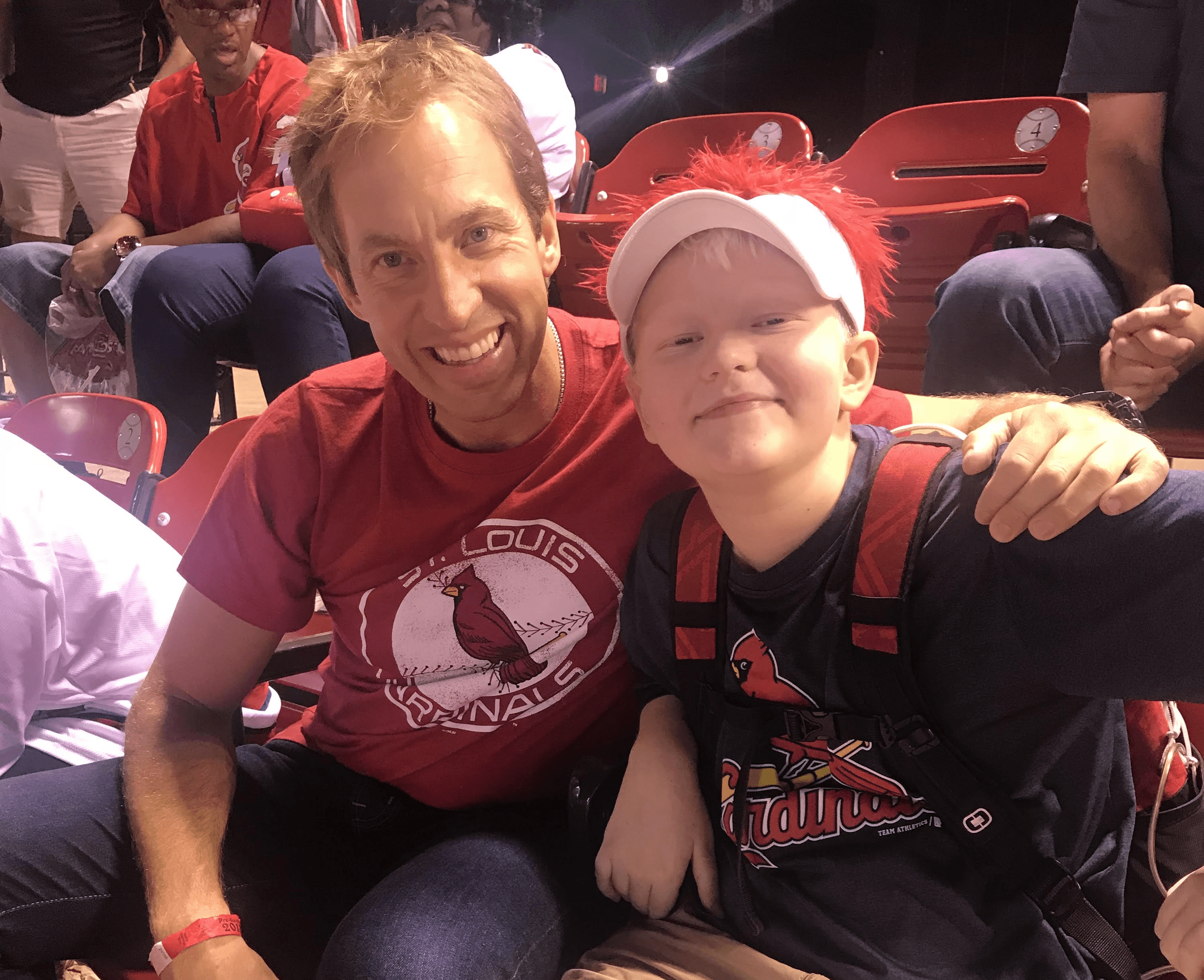 Ryan Kelley sitting with Alec at a baseball game.